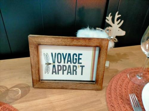 a sign on a table with a wine glass at Voyage Appar't, location de gite Vendée et Puy du Fou in Tiffauges