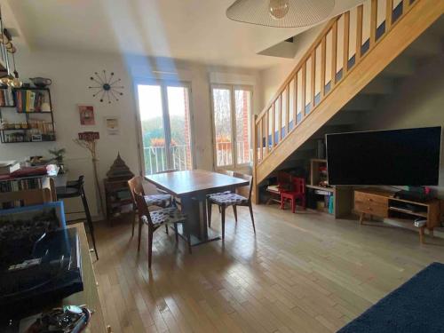 un salon avec une table et une télévision dans l'établissement Nice duplex flat in Saint-Denis 1km Stade de France, à Saint-Denis