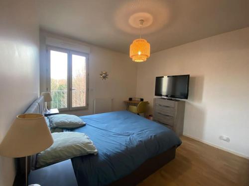 une chambre avec un lit et une télévision à écran plat dans l'établissement Nice duplex flat in Saint-Denis 1km Stade de France, à Saint-Denis