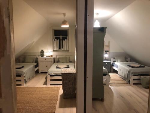 ein Dachzimmer mit drei Betten und einer Treppe in der Unterkunft Dom z Bieszczad na Kaszubach - całoroczny dom z balią ogrodową in Kowalewo