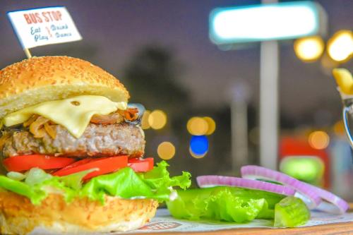a hamburger with cheese and vegetables on a table at Sanafir Hotel - El Pacha Suites Sharm - Adults Only in Sharm El Sheikh