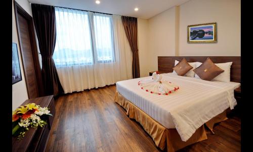 a hotel room with a large bed with flowers on it at Lenid Ocean View Hotel in Nha Trang