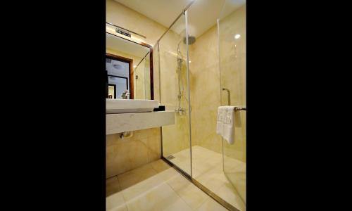 a bathroom with a sink and a glass shower at Lenid Ocean View Hotel in Nha Trang