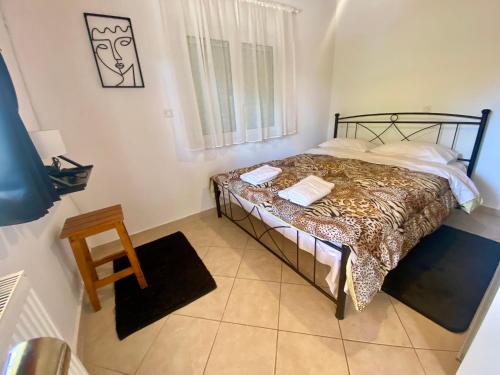 a bedroom with a bed in a room with a window at Nefele - Athens Airport Home in Artemida