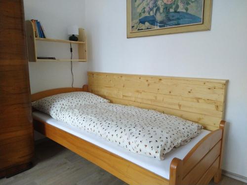 a bed in a room with a wooden headboard at Apartmán Špuntárna in Polná
