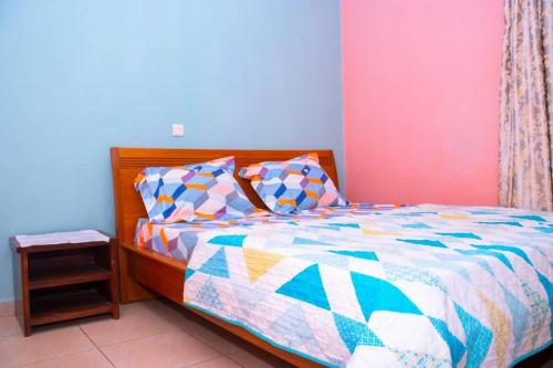 雅溫德的住宿－Appartement meublé 2 chambres Montée Jouvence，一间卧室配有一张带五颜六色棉被的床