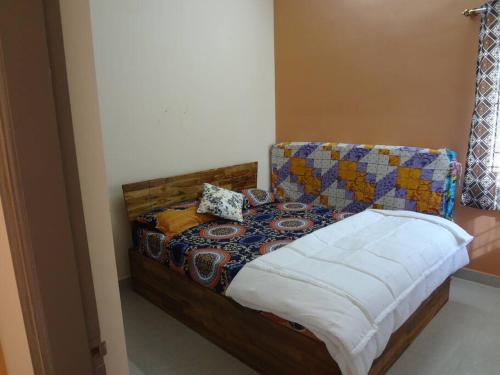 1 dormitorio con 1 cama con edredón en Charm Ville - Villa with Nature in Hosur en Hosūr