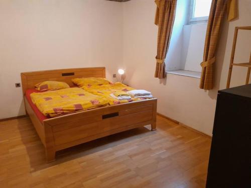 um quarto com uma cama com um edredão amarelo e uma janela em Old Central 2-room souterrain flat em Brno