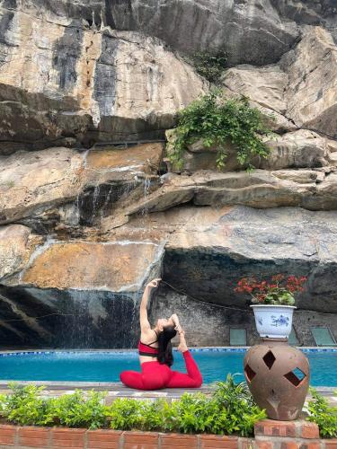 a woman sitting in front of a waterfall at Trang An Memory Homestay in Ninh Binh