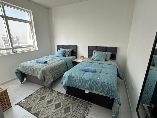a bedroom with two beds and a window at Luxury Appartement Amazing View 130m2 Al Majaz 3 in Sharjah