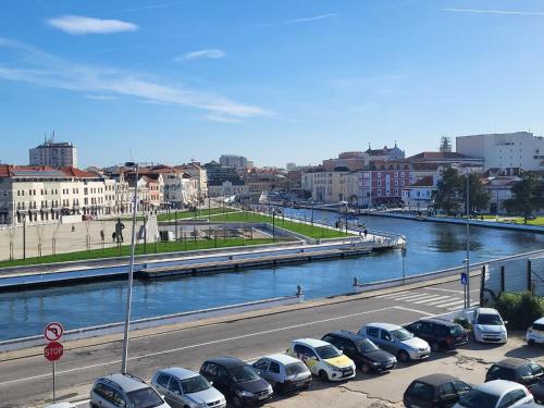 a row of cars parked in a parking lot next to a river at Rosa D'Aveiro in Aveiro