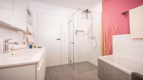 a white bathroom with a shower and a sink at Radochsbergloft in Abtenau