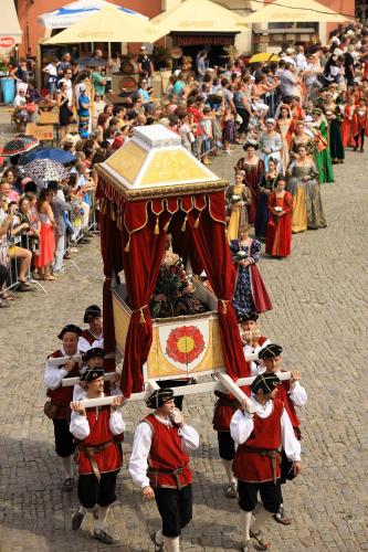a group of men in traditional costumes walking in a parade at Hotel Konvice in Český Krumlov