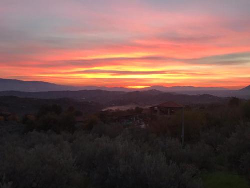 a sunset over the mountains with a house in the foreground at House near Rome with Beautiful Views and Pool in Piglio