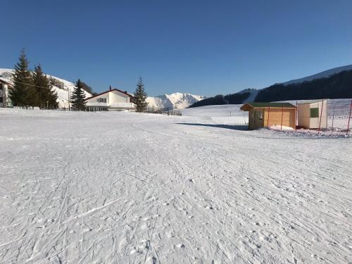 a snow covered field with a building in the background at House near Rome with Beautiful Views and Pool in Piglio