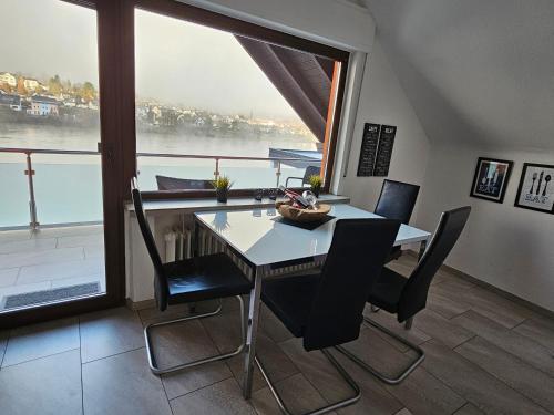 Moselkieker في برودنباخ: غرفة طعام مع طاولة وكراسي ونافذة كبيرة