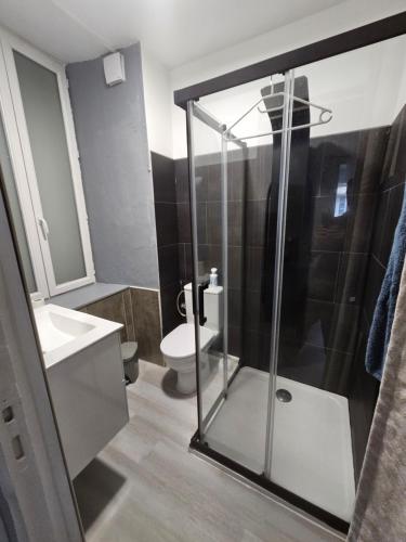 une salle de bain avec une douche en verre et des toilettes dans l'établissement Sarl la famille 1, à Angoulême