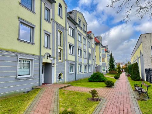 uma fila de casas numa rua com um banco em Nadmorski Chill - Comfy Apartments em Gdansk