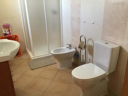 a bathroom with a toilet and a sink at Monte da Palmeirinha in Vila Nova de Milfontes
