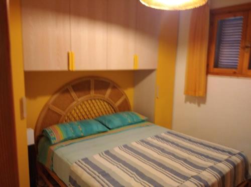 een slaapkamer met een bed met een houten hoofdeinde bij Ibiscus Casa Marina in Campomarino