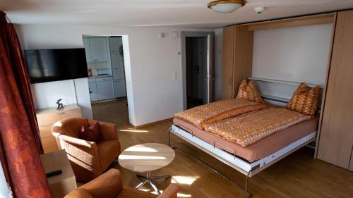 a living room with a bed and a couch at Ferienwohnungen Hotel Eden Spiez in Spiez