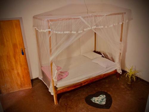 ein kleines Bett mit Baldachin in einem Zimmer in der Unterkunft Obeisance in Tangalle