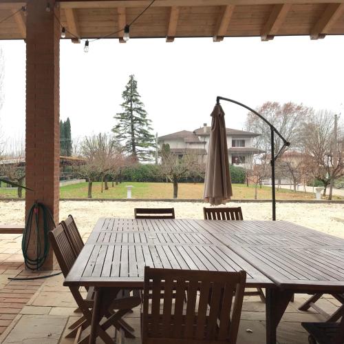 una mesa de madera con sillas y una sombrilla cerrada en Le Colombe en Beccacivetta