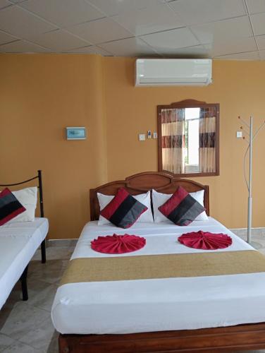 a bedroom with a bed with red flowers on it at Power Zone Guest House in Matale