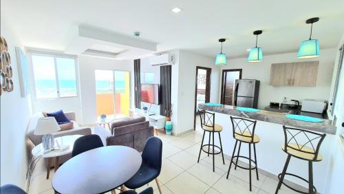a kitchen and living room with a table and chairs at Suite con Vista al Mar, Piscinas, Jacuzzi, Wifi in Playas