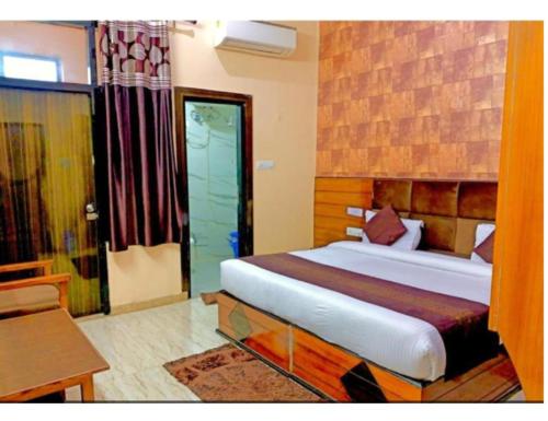 a bedroom with a bed and a desk and a window at Hotel Highway, Udhampur in Udhampur