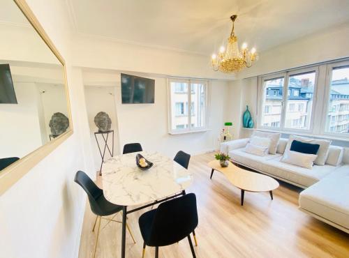 a living room with a table and chairs and a couch at Home Sweet Home - Design & Zen in Luxembourg