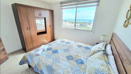 1 dormitorio con 1 cama con edredón y ventana en Suite con Vista al Mar, Piscinas, Jacuzzi, Wifi, en Playas