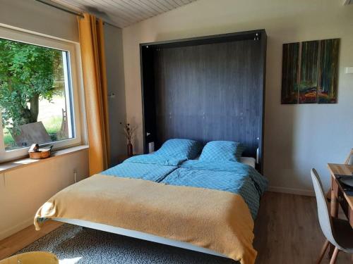 1 dormitorio con 1 cama grande y ventana en WalHOME: Hohes Venn, 3 Grenzen, Natur, 