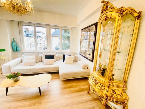 Home Sweet Home - Design & Zen في لوكسمبورغ: غرفة معيشة مع مرآة ذهبية وأريكة