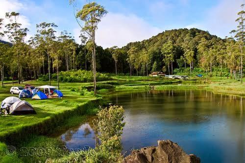 a group of tents sitting next to a lake at Wong Deso Camping in Seminyak