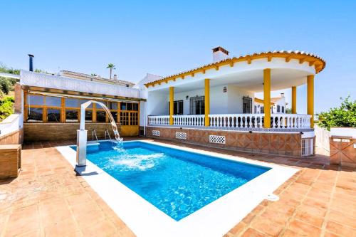 a swimming pool in front of a house at CASA RURAL VILLAMAYNO in Alcaucín