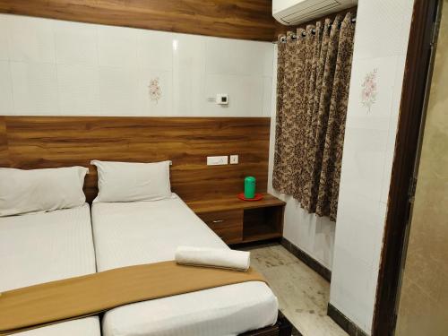 a bedroom with two beds and a window at Nile Guest House in Chennai