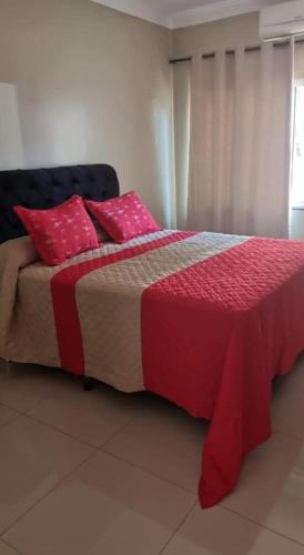 ein Schlafzimmer mit einem großen Bett mit rosa Kissen in der Unterkunft casa entero piscina privada in Aparecida de Goiania