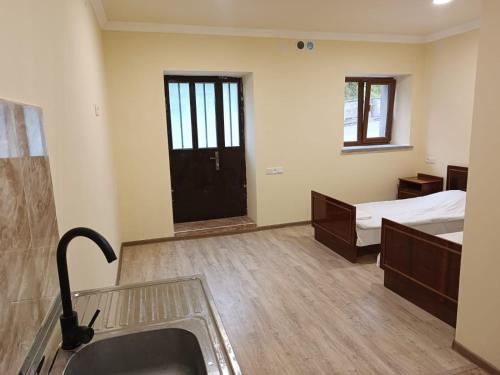 a bathroom with a sink and a bedroom with a bed at Verishen Guest House B&B in Goris