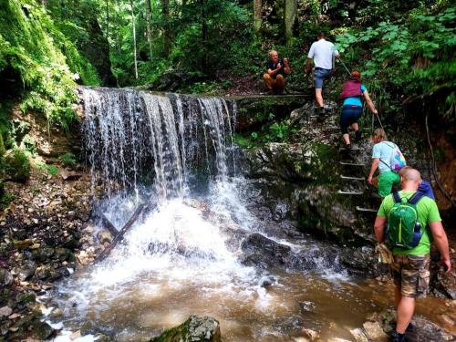 a group of people walking through a waterfall at Penzión Zbojnícky Halaš in Tisovec