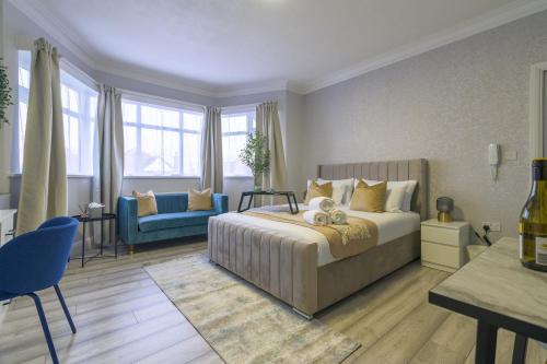 1 dormitorio con 1 cama y 1 sofá azul en 12 Elmwood, en Harrow