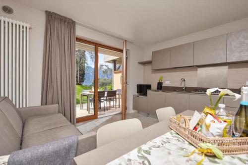 a kitchen and living room with a couch and a table at CallaLillyJardin in Malcesine