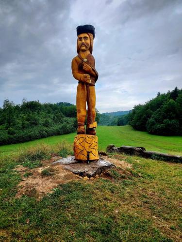 a statue of a man standing on top of a field at Penzión Zbojnícky Halaš in Tisovec