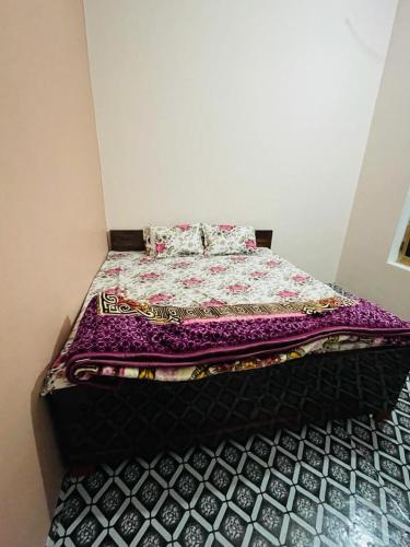 Una cama con edredón en una habitación en Ashu Homestay, en Ayodhya