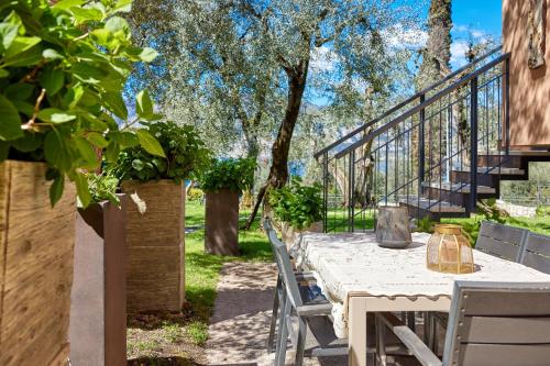 a table and chairs on a patio with trees at CallaLillyJardin in Malcesine