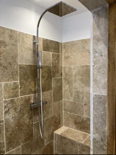 une douche avec une porte vitrée dans une salle de bain dans l'établissement Mas des Roses, à Cavaillon