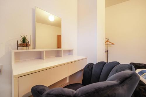 a living room with two blue chairs and a mirror at Serviced Accommodation Next to Liverpool city Centre/station / stadium in Liverpool