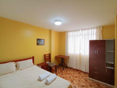 a bedroom with a bed and a table and a window at A y J Familia Hospedaje in Lima