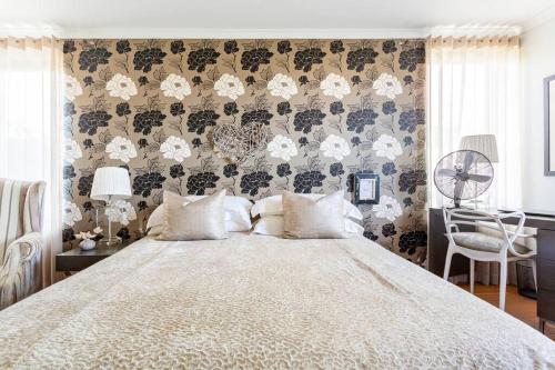 a bedroom with a large bed with a floral wallpaper at Little Lake Haven in Cape Town
