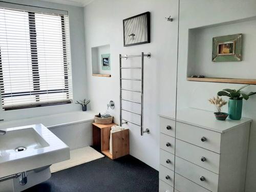 a bathroom with a sink and a bath tub at Little Lake Haven in Cape Town